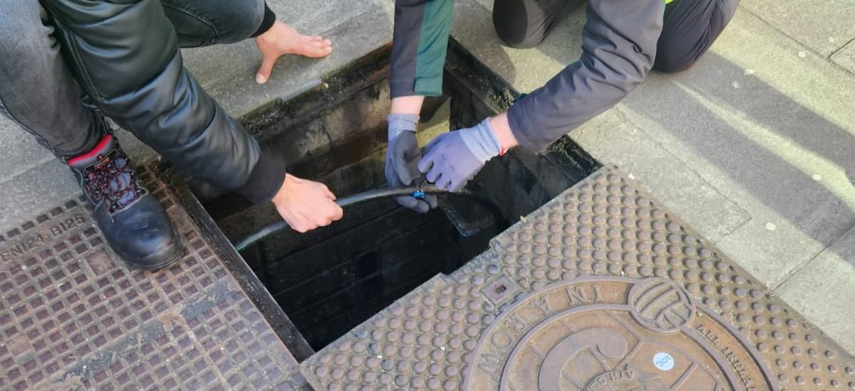 Engineers opening a tagged chamber lid in Dublin
