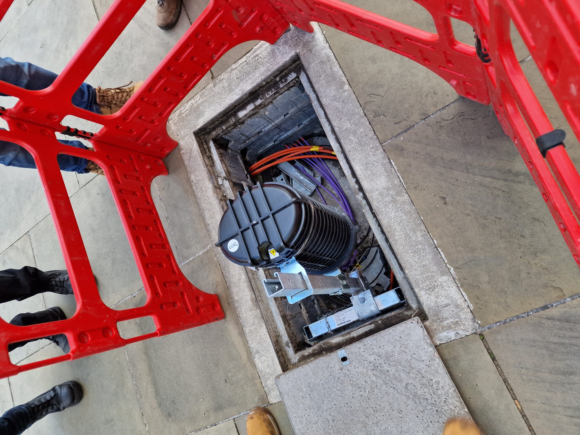 Auto-stamped site photo: a LOC-tagged splice closure in an open chamber